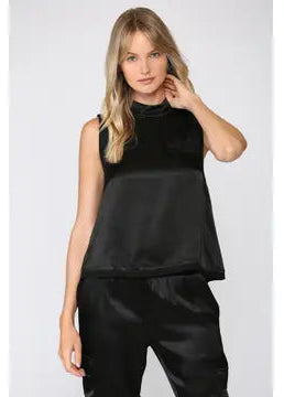 Woman wearing a black sleeveless top and pants on a white background